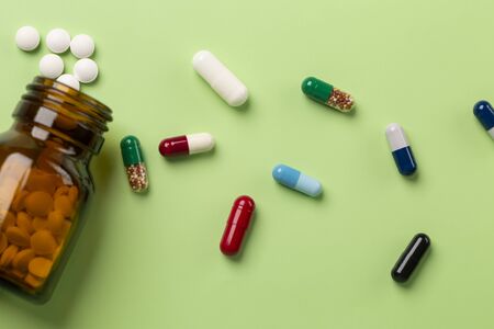 Different medications. Glass pill bottles. Green backdrop.の写真素材