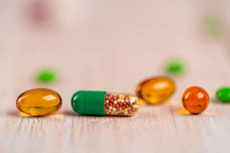 Home therapy. Green medicine capsule of microgranules and fish oil pillsの写真素材