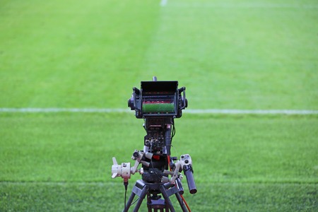 Professional digital TV camera on the green grass of a soccer fieldの写真素材