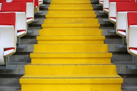 Yellow stairs and rows of seats at the tribune of modern stadiumの写真素材