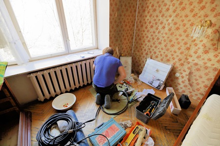 Worker replaces domestic radiator in the living roomの写真素材