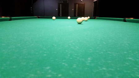 Ivory billiard ball on the green cloth of the table to play