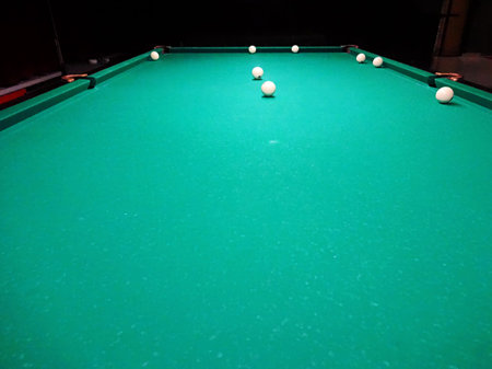 Ivory billiard ball on the green cloth of the table to play