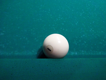 Ivory billiard ball on the green cloth of the table to playの写真素材