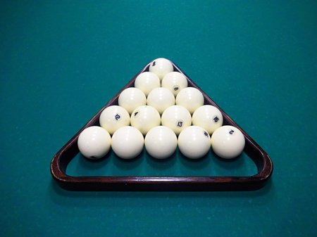 Ivory billiard ball on the green cloth of the table to play