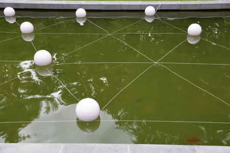 White round buoys in the water pond in a city park in the summer