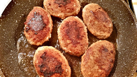 Fresh fried cutlets with oil in a frying pan