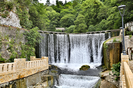 Small beautiful waterfall in the center of the ancient city in the summerの写真素材