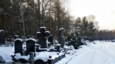 Gravestones in the cemetery under the winter snowの写真素材