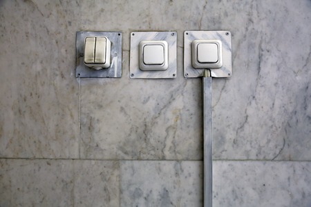 Four white household electric switches on a marble wallの写真素材