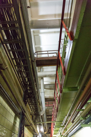 Ceiling in the shop of the production plant with iron pipes