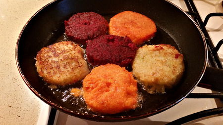 Juicy appetizing multicolored cutlets from carrots, beets and cabbage fried on a panの写真素材