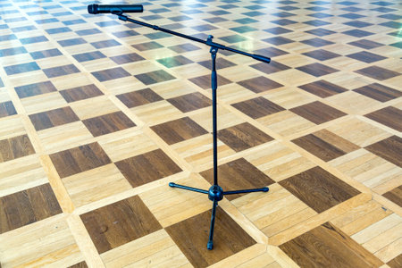 Black metal stand with microphone stands on a parquet floorの写真素材