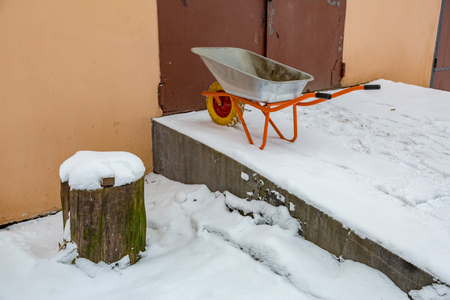 Iron trolley for manual moving of building materials in the snow in the backyardの写真素材