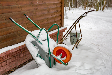 Iron trolley for manual moving of building materials in the snow in the backyardの写真素材