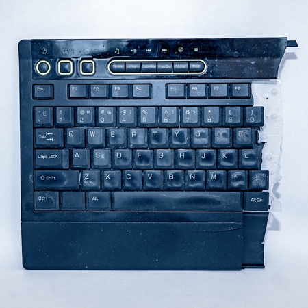 Destroyed dirty computer keyboard on a light backgroundの写真素材