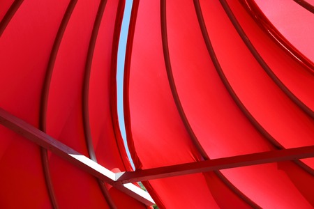 Abstract installation of metal beams and bright satin red fabricの写真素材