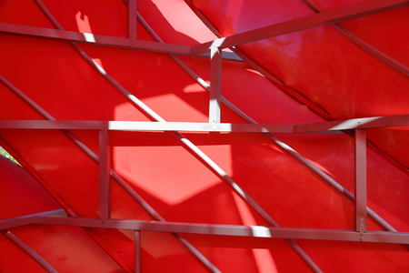 Abstract installation of metal beams and bright satin red fabricの写真素材