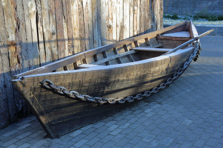 Old abandoned wooden boat on the shore of the boat station