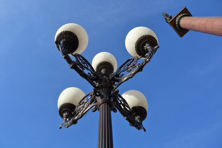 Vintage iron lantern on a city street against the blue skyの写真素材