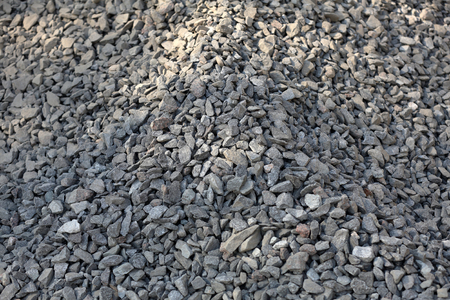 Gray textured surface of a heap of construction pebbles and gravelの写真素材