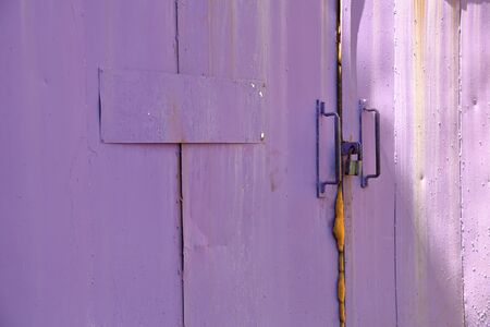 Purple metal gates are locked and glued with foamの写真素材
