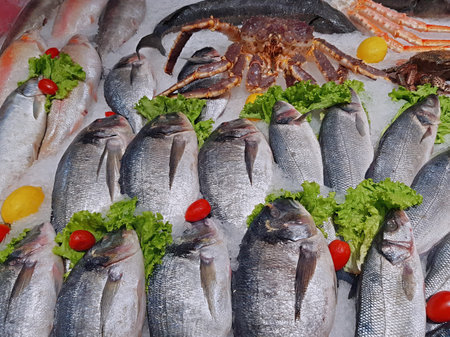 A lot of fresh raw fish on store shelve with ice