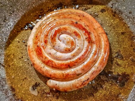 German style spiral fried sausage for beer. Fried in a pan in vegetable oilの写真素材