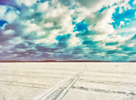 A long curved track in the snow and a dramatic sky above the horizon. Illustrationの写真素材