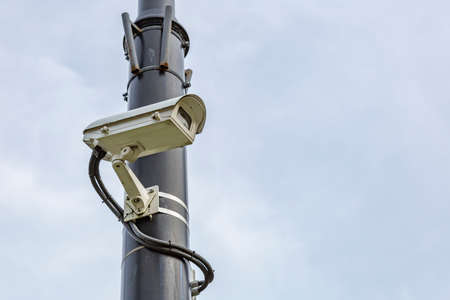 Outdoor security camera on a lamppost in the public parkの写真素材