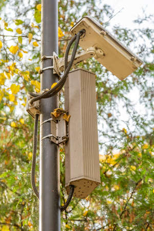 Outdoor security camera on a lamppost in the public parkの写真素材