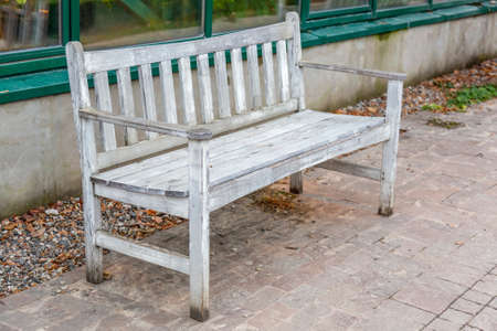 A recreation bench made of wood in a city park in autumnの写真素材