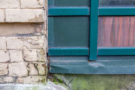 Textured surface of part of an old wall made of metal, stone and glassの写真素材