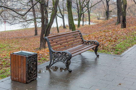 A recreation bench made of wood in a city park in autumn