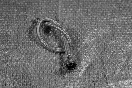 Plumbing hose in a metal braid for supplying water to the kitchen and bathroom