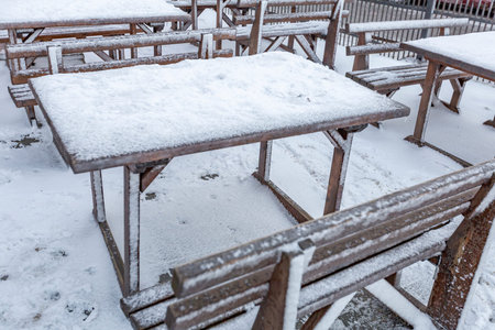 A furnished outdoor cafe without people covered with a thick layer of snow