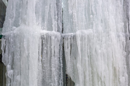 Winter icicles hanging from the eaves of the glass building