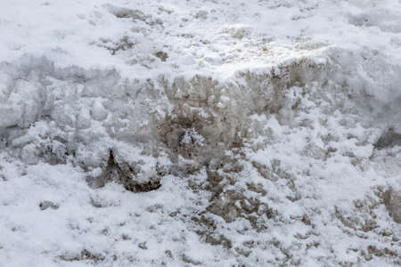 Textured surface of dirty melting snow with ground and soilの写真素材