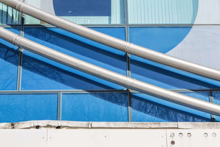 Harmonious combination of industrial piping and the exterior of a modern buildingの写真素材