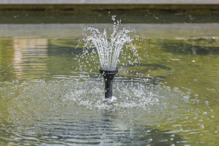 Small fountain in a city public park in the summer sunny dayの写真素材