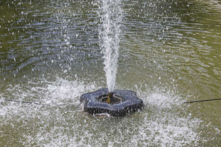 Small fountain in a city public park in the summer sunny dayの写真素材