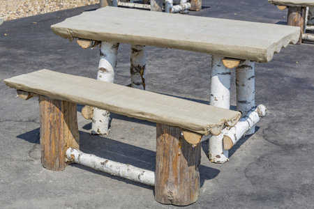 Vacant bench and table made of natural birch in an outdoor summer cafe