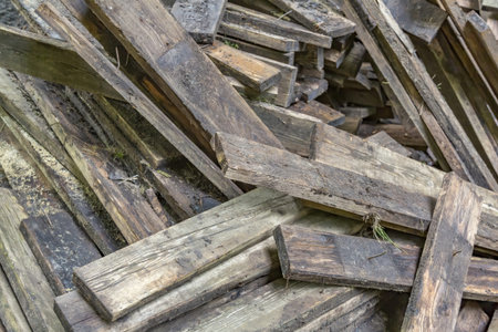 Heap of dirty wooden boards for the construction and improvement of the yard
