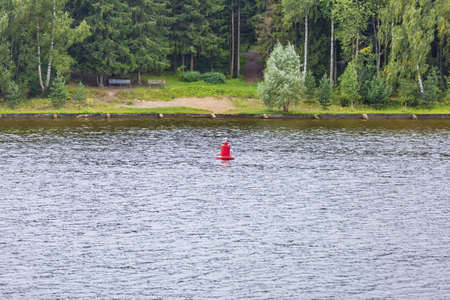 Calm river water surface and iron navigation buoyの写真素材