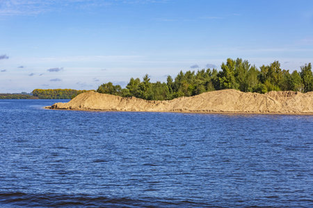 Scenic river landscape with green trees in early autumn