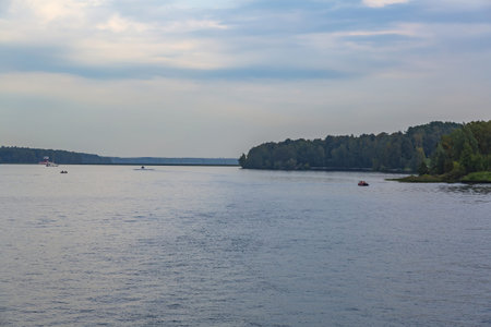 Scenic river landscape with green trees in early autumn
