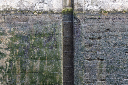 Textured surface of gray concrete wall with scratches and cracks