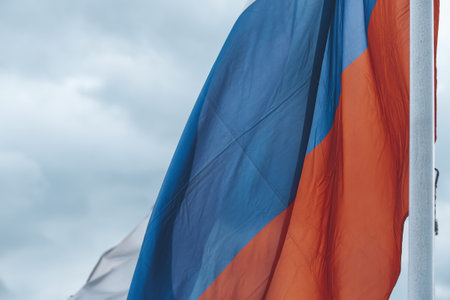 The tricolor state flag of Russia on a cloudy sky backgroundの写真素材