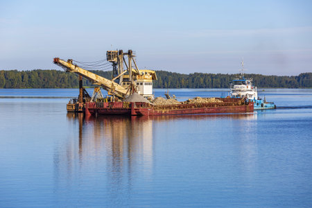 Yaroslavl Region, Russia - September 11, 2021: Tugboat Captain Petrov and a barge with sand float on...
