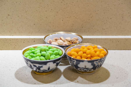 Peanut kernels in a bright orange and green peppery shell and fried pistachiosの写真素材